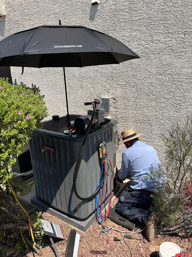 HVAC technician performing outdoor AC maintenance in Porterville